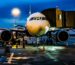 A commercial airplane on the runway at Bengaluru airport during night with a blue sky backdrop.