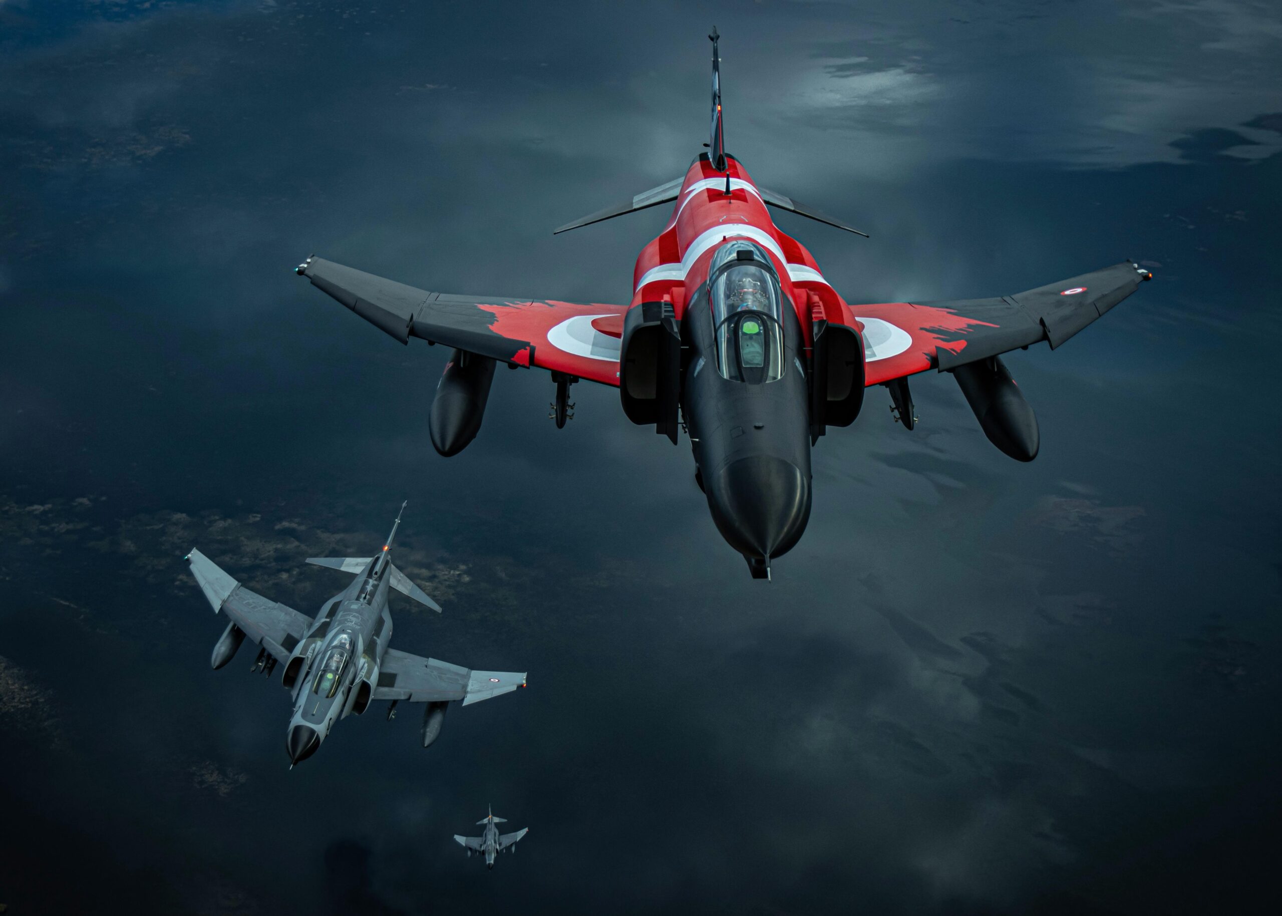 Three jet fighters soar through the sky in a dramatic aerial formation, showcasing their power.